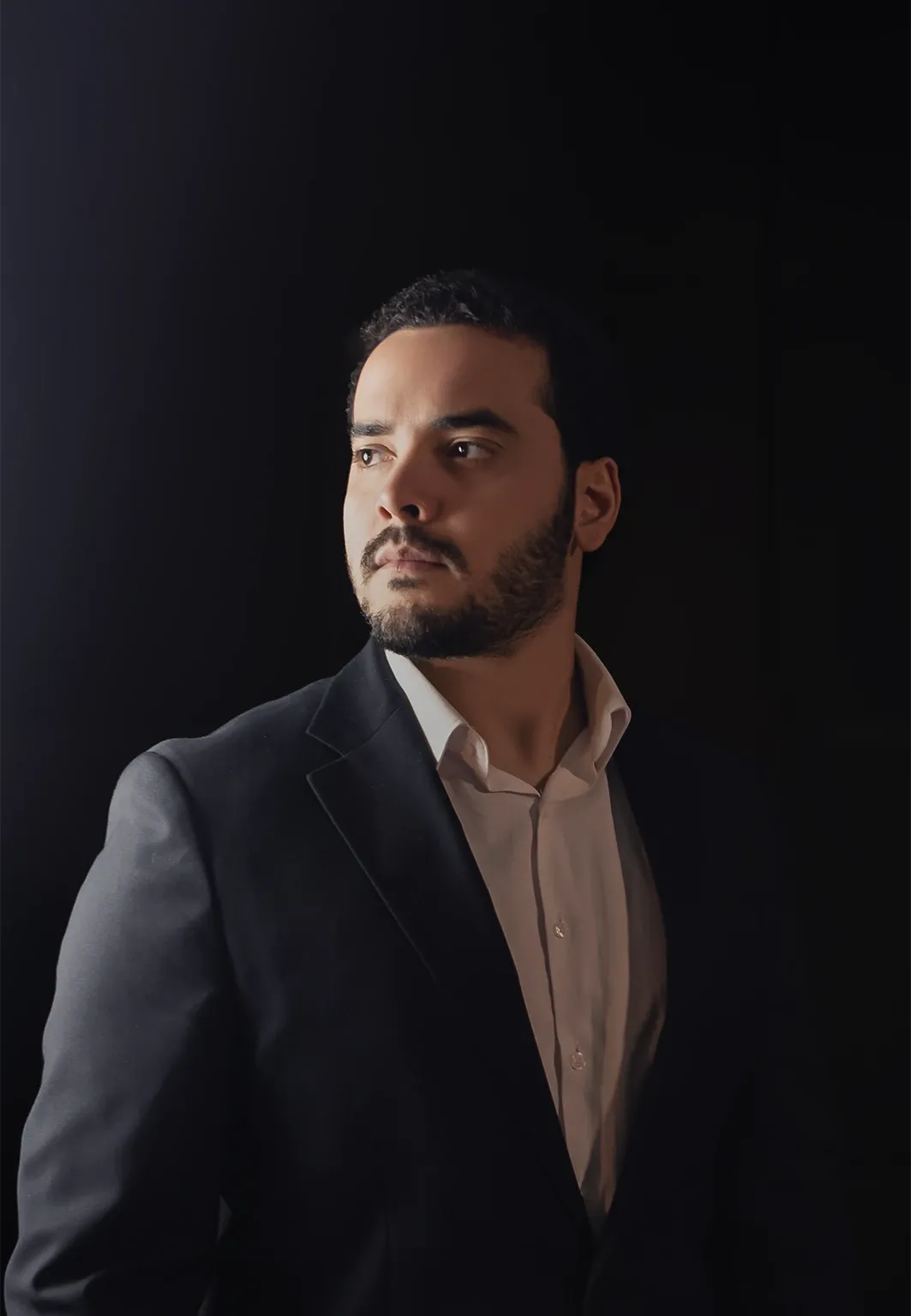 Retrato de Cauê Oliveira de perfil, de fato escuro